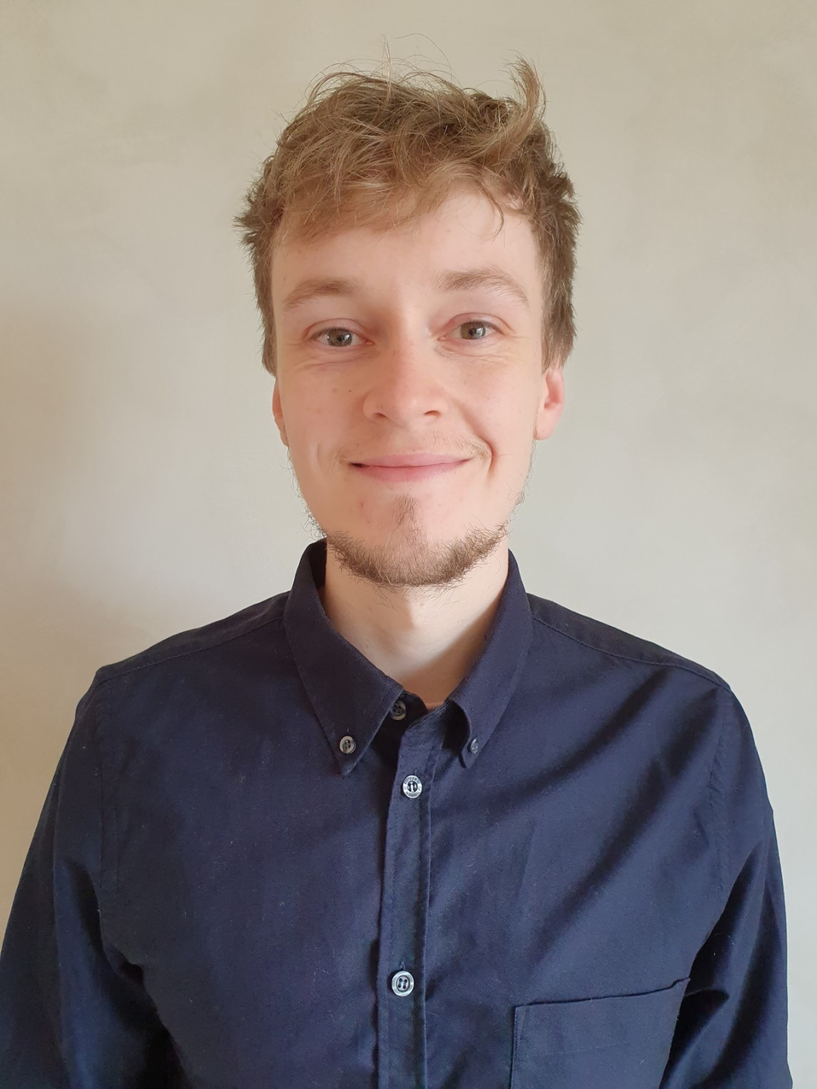 Tobias Thurøe Ersted's portrait with him smiling and wearing a dark blue shirt.